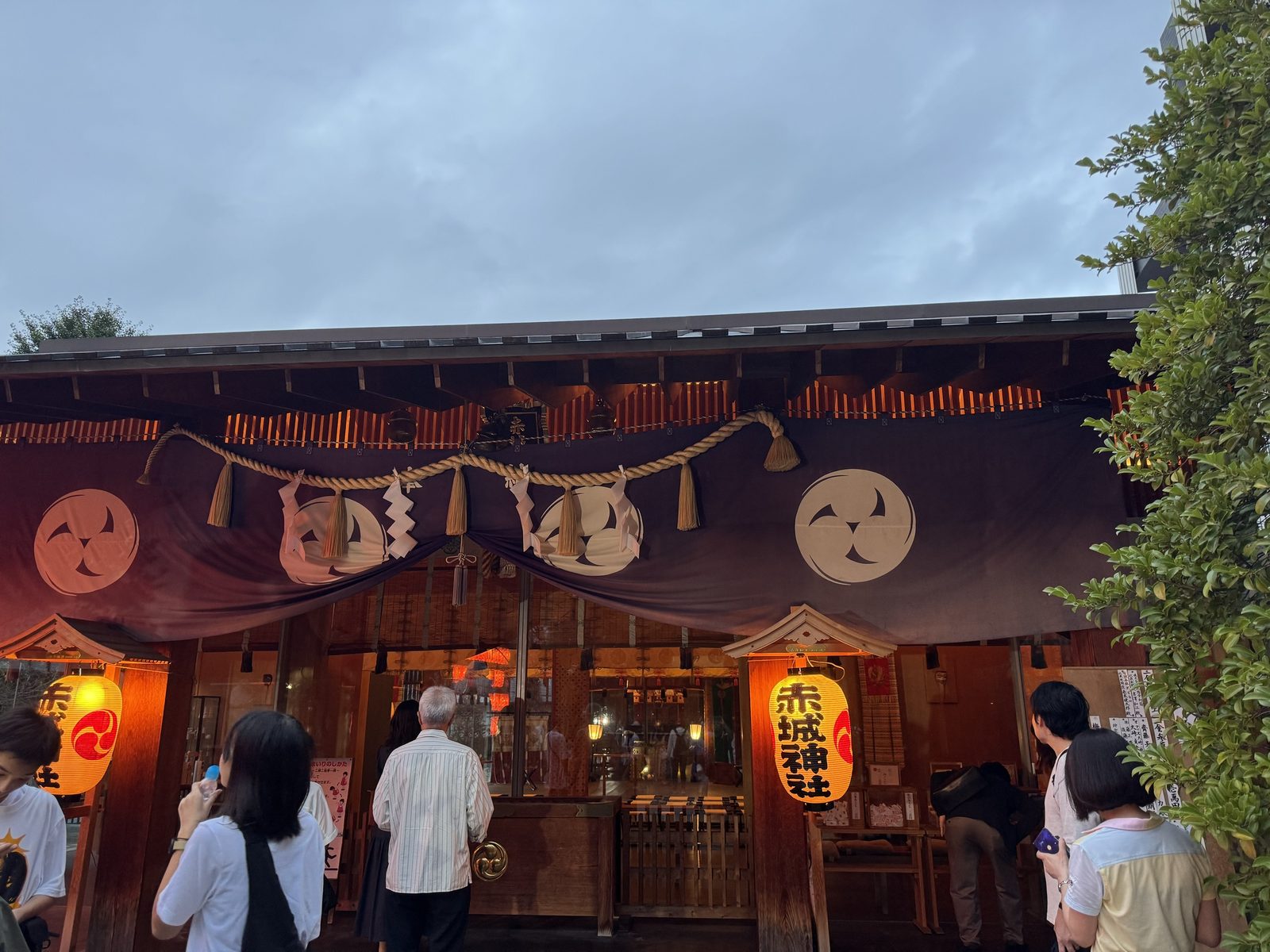 例大祭の夕方、三つ巴の紋が入った幔幕と提灯が掛けられた赤城神社の社殿